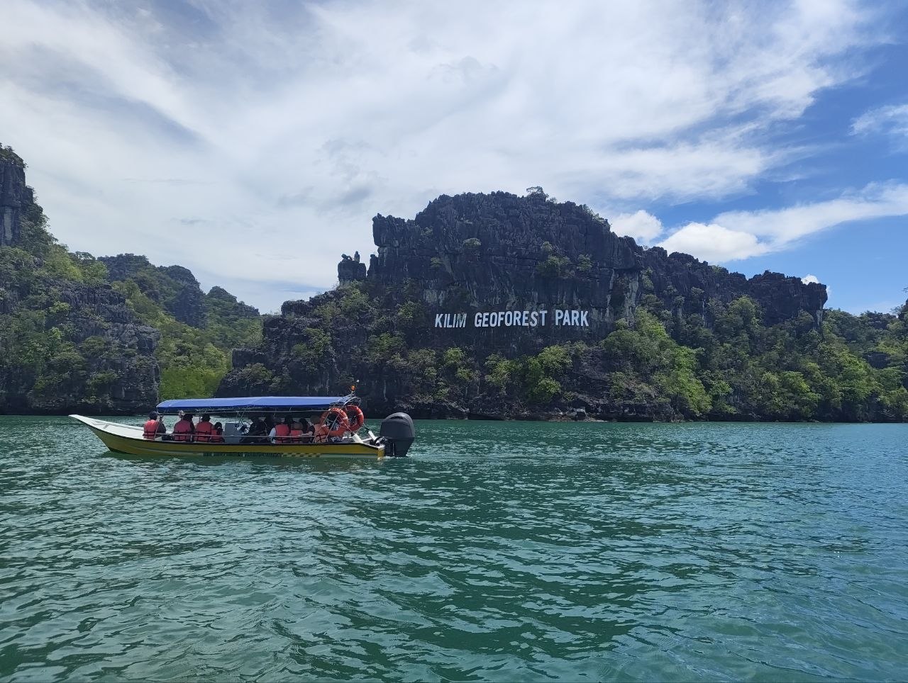 Знак Kilim Geoforest Park с лодкой и бирюзовой водой